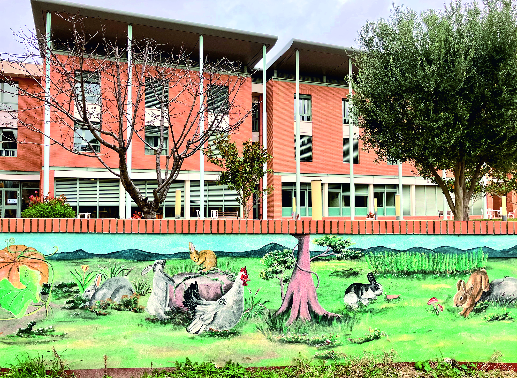 Grande maison rouge avec un mur avec des animaux peints